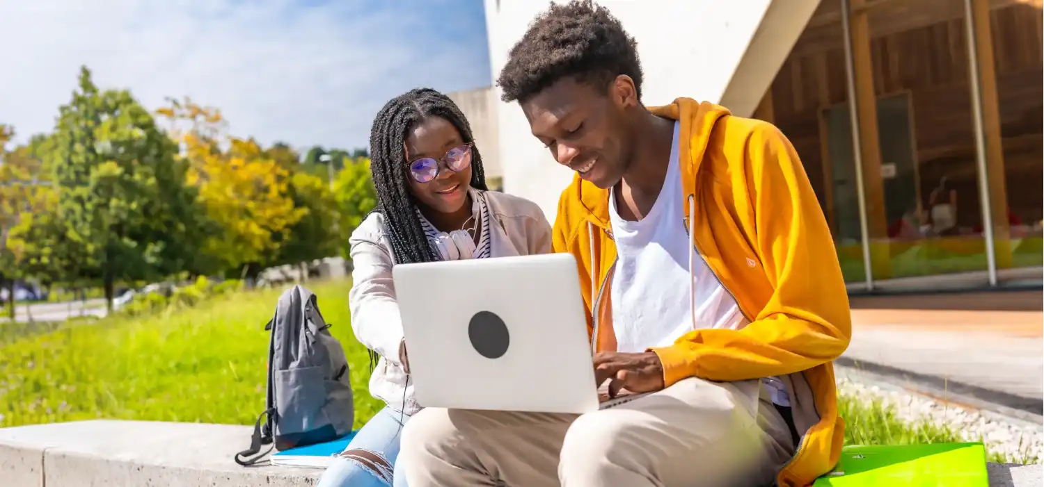 african students using laptop studying together outside campus4